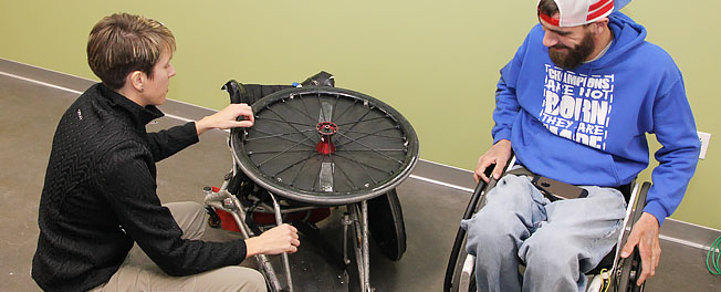 Photo of Sue Tucker adjusting wheelchair for client